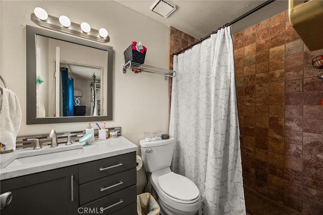 bathroom with toilet, vanity, a textured ceiling, and walk in shower