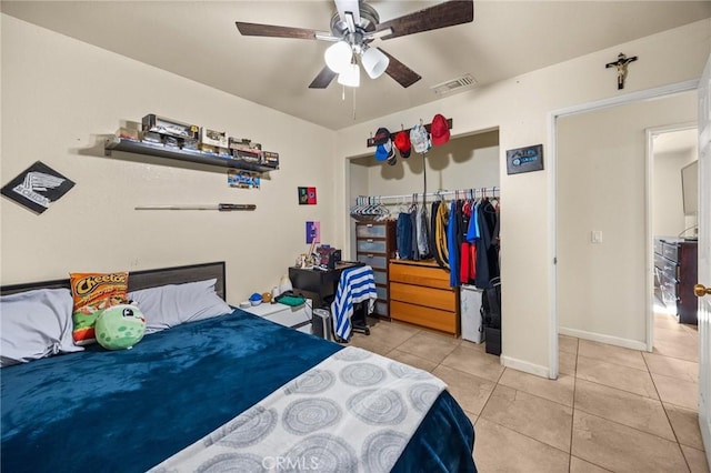 tiled bedroom with ceiling fan and a closet