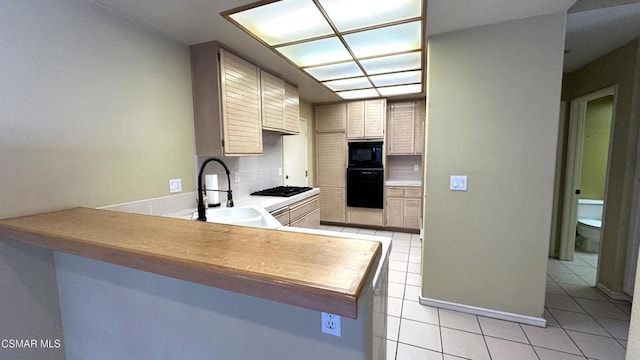 kitchen with black appliances, sink, decorative backsplash, light tile patterned flooring, and kitchen peninsula