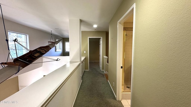 hallway featuring dark colored carpet