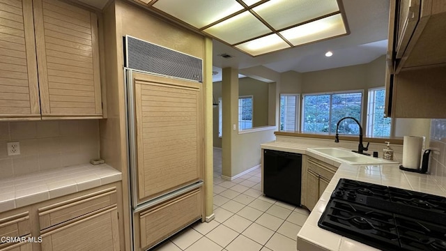 kitchen with tasteful backsplash, sink, black appliances, light tile patterned floors, and tile countertops