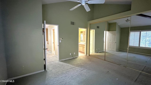 unfurnished bedroom with light carpet, high vaulted ceiling, ensuite bath, ceiling fan, and a closet