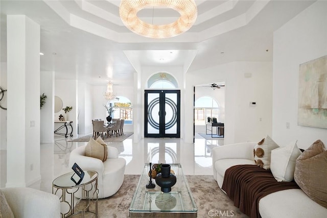 living room featuring a ceiling fan and a raised ceiling