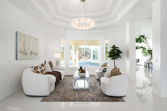 living area with baseboards and a tray ceiling