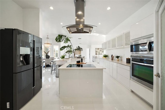 kitchen with white cabinets, island exhaust hood, modern cabinets, a kitchen island, and black appliances
