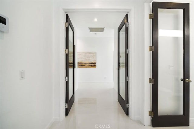 hallway with visible vents and baseboards