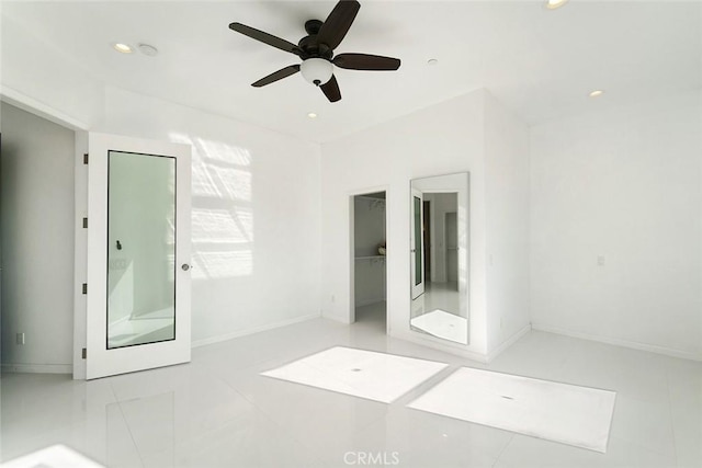 unfurnished bedroom with ceiling fan, recessed lighting, baseboards, tile patterned floors, and a walk in closet