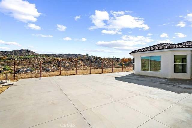 view of patio with fence and a mountain view