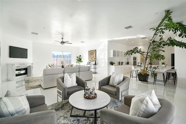 living area with a high end fireplace, a ceiling fan, visible vents, and recessed lighting