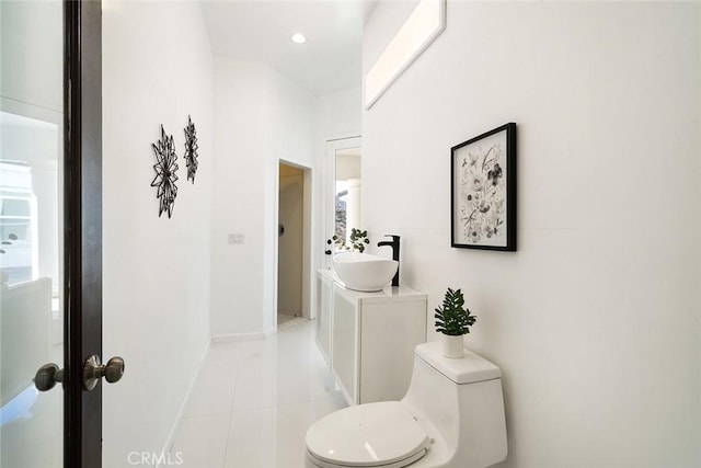 bathroom with baseboards, toilet, tile patterned floors, vanity, and recessed lighting