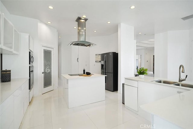 kitchen with a kitchen island, a sink, island range hood, modern cabinets, and black appliances