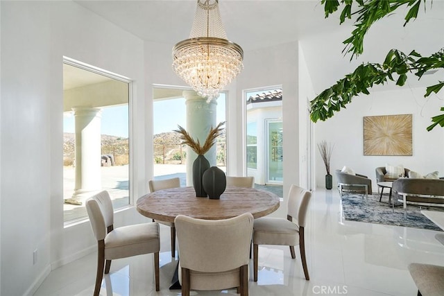 dining area with baseboards, tile patterned flooring, a wealth of natural light, and a notable chandelier