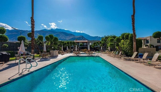 view of pool with a patio area and a mountain view