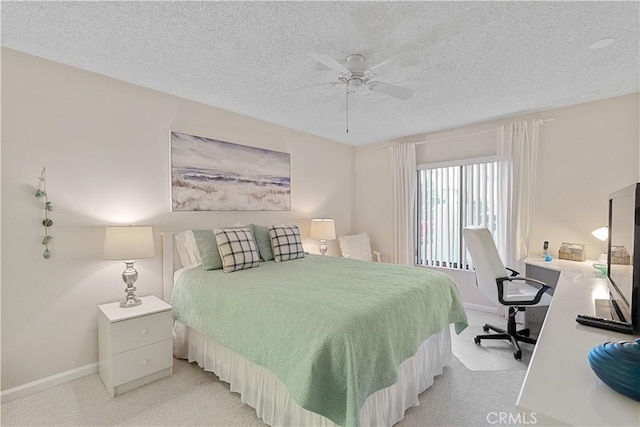 bedroom with a textured ceiling, ceiling fan, and light colored carpet