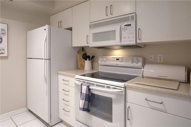 kitchen featuring light tile patterned floors, white cabinets, and white appliances