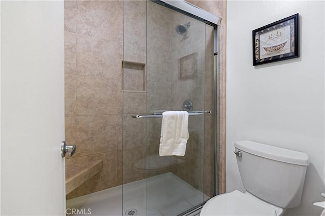 bathroom with toilet and an enclosed shower