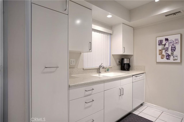 kitchen with white cabinets, dishwasher, sink, and light tile patterned floors