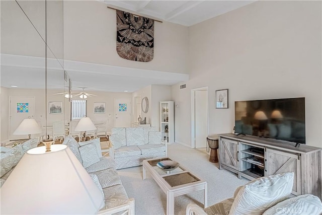 living room featuring ceiling fan, beam ceiling, and light carpet