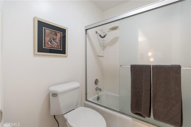 bathroom featuring toilet and combined bath / shower with glass door