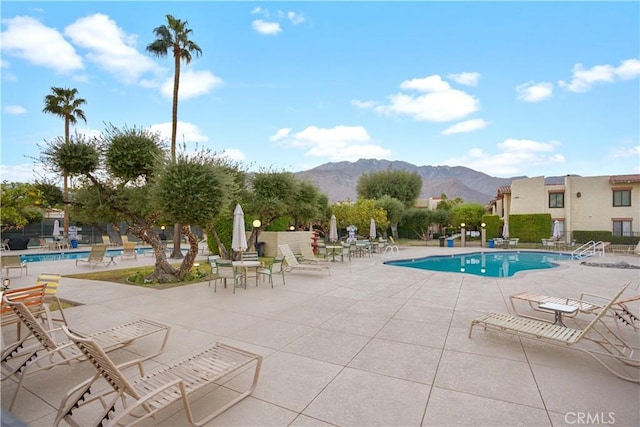 view of swimming pool featuring a patio area and a mountain view