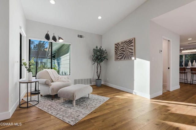 living area with wood-type flooring and vaulted ceiling