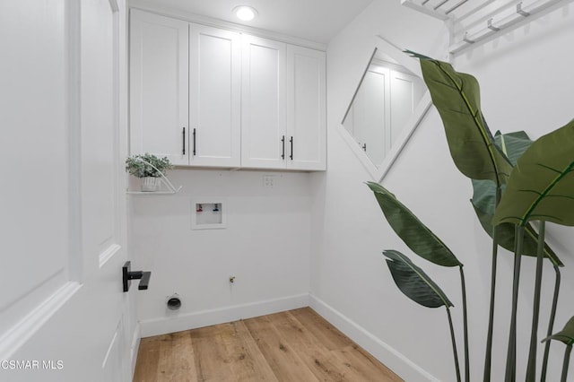 laundry area with light wood-type flooring, cabinets, hookup for a washing machine, and hookup for an electric dryer