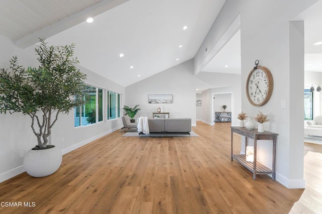 living room with vaulted ceiling with beams, light hardwood / wood-style floors, and plenty of natural light