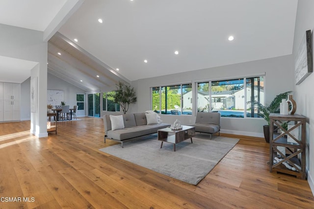 living room featuring light wood-type flooring, beam ceiling, and high vaulted ceiling