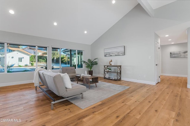 living room featuring high vaulted ceiling and light wood-type flooring