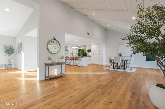 interior space with high vaulted ceiling, light wood-type flooring, wood ceiling, and beamed ceiling