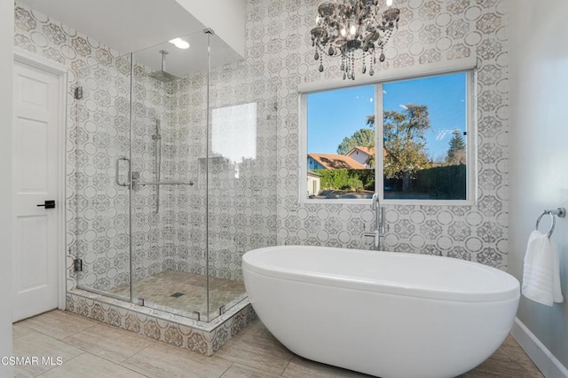 bathroom with independent shower and bath, a notable chandelier, and tile patterned floors