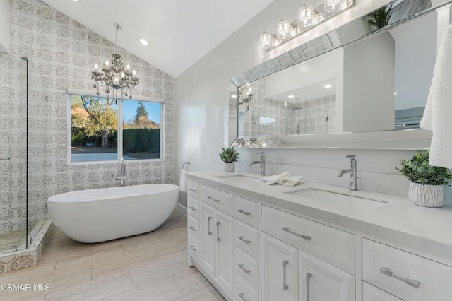 bathroom featuring lofted ceiling, vanity, tile patterned floors, an inviting chandelier, and plus walk in shower