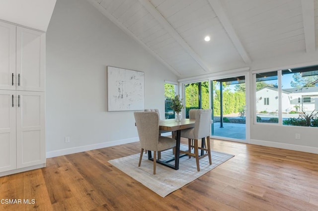 dining area featuring vaulted ceiling with beams and light wood-type flooring