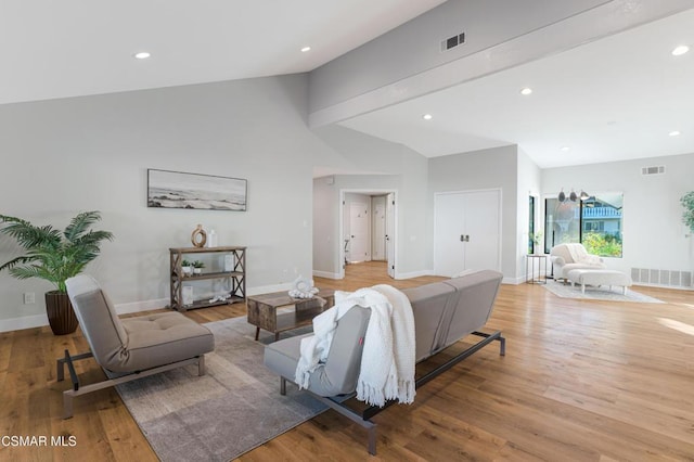 living room featuring light hardwood / wood-style floors and high vaulted ceiling