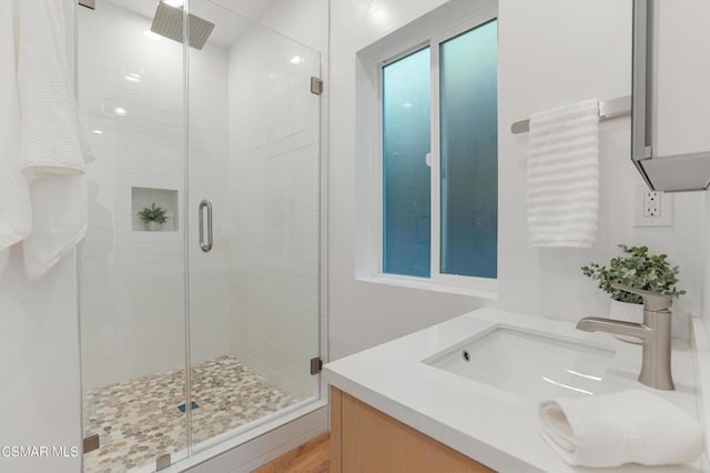 bathroom with an enclosed shower and sink