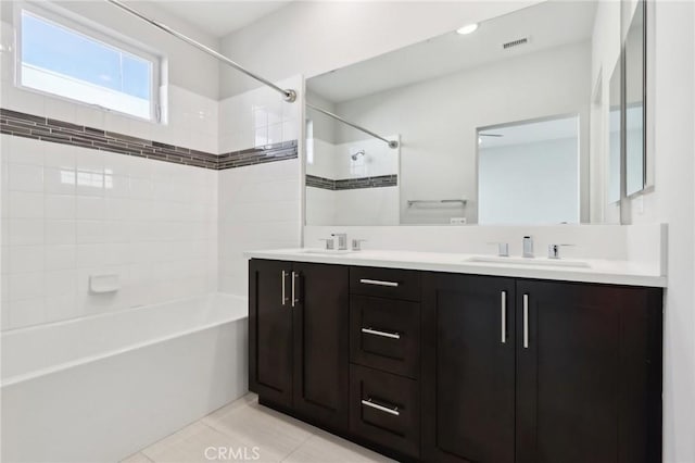 bathroom featuring vanity, tile patterned floors, and tiled shower / bath