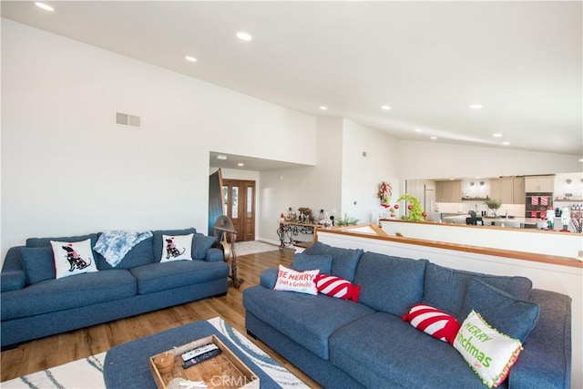 living room featuring light hardwood / wood-style floors and high vaulted ceiling