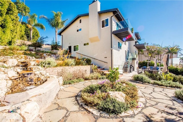 view of side of property with a patio area and a balcony