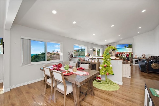 dining room with light hardwood / wood-style flooring and lofted ceiling