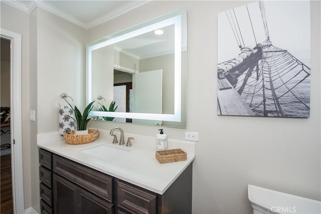 bathroom with vanity, toilet, and crown molding