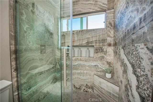 bathroom featuring toilet and an enclosed shower