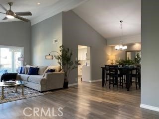 living room with high vaulted ceiling, ceiling fan with notable chandelier, and hardwood / wood-style flooring