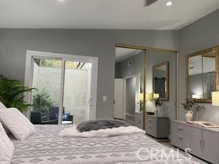 bedroom featuring lofted ceiling, a closet, and access to outside