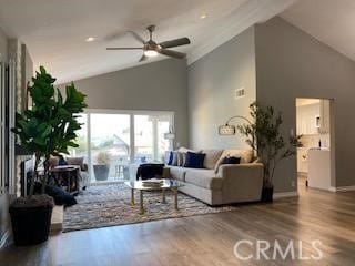 living room with ceiling fan, hardwood / wood-style floors, and vaulted ceiling