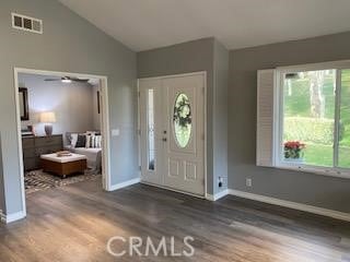 foyer entrance with ceiling fan, dark hardwood / wood-style flooring, and vaulted ceiling