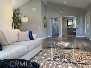 living room with hardwood / wood-style floors and high vaulted ceiling