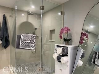 bathroom with a shower with shower door and basketball hoop