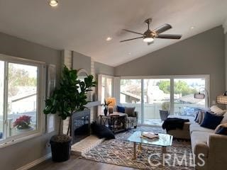 living room featuring ceiling fan, plenty of natural light, wood-type flooring, and vaulted ceiling