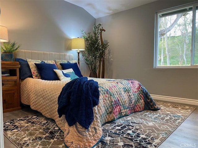 bedroom with vaulted ceiling and wood-type flooring