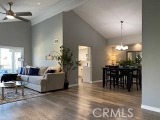 living room with ceiling fan with notable chandelier, wood-type flooring, and high vaulted ceiling